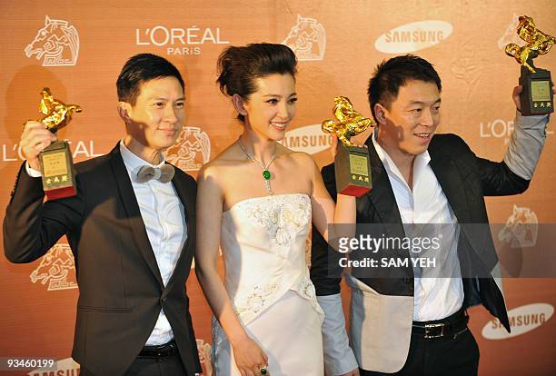 Hong Kong actor Nick Cheung, , Chinese actress Li Bingbing and actor Huang Bo hold trophies after winning the Best Leading Actors and Actress awards...