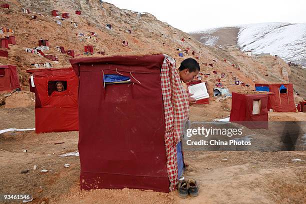 Nun reads in a crude cabin where she will stay secluded for 100 days at the Yachen Gar Monastery on November 27, 2009 in Baiyu County of Ganzi...