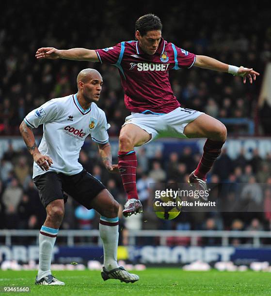 Guillermo Franco of West Ham is challenged by Clarke Carlisle of Burnley during the Barclays Premier League match between West Ham United and Burnley...