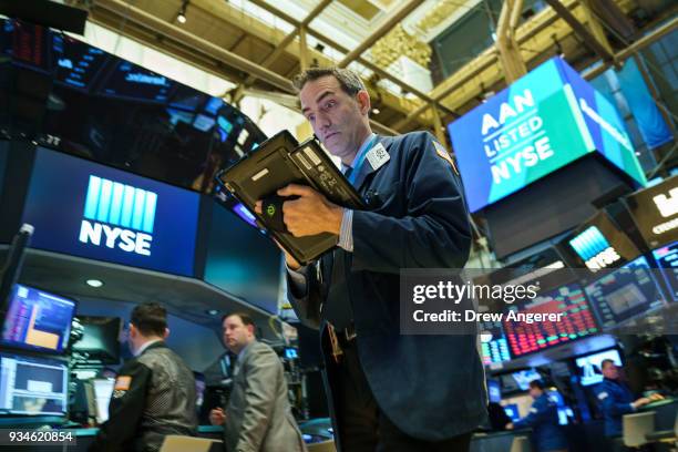 Traders and financial professionals work ahead of the closing bell on the floor of the New York Stock Exchange , March 19, 2018 in New York City. The...