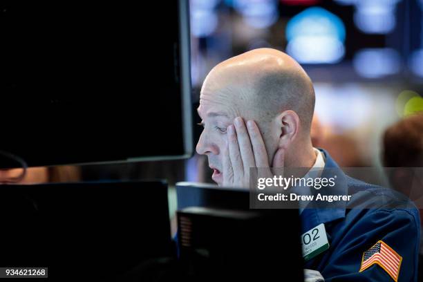 Traders and financial professionals work ahead of the closing bell on the floor of the New York Stock Exchange , March 19, 2018 in New York City. The...