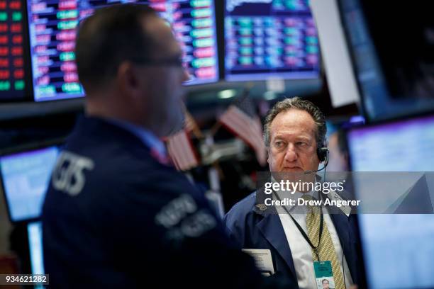 Traders and financial professionals work ahead of the closing bell on the floor of the New York Stock Exchange , March 19, 2018 in New York City. The...