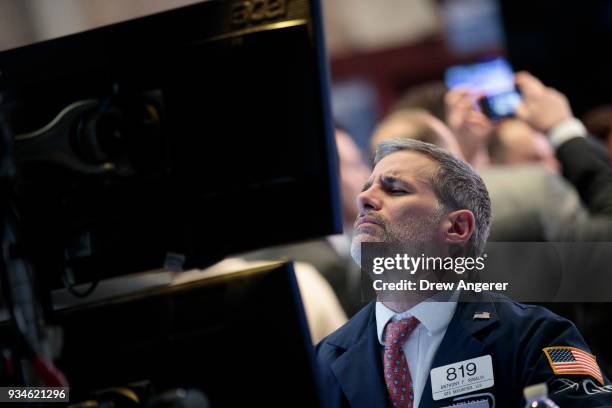 Traders and financial professionals work ahead of the closing bell on the floor of the New York Stock Exchange , March 19, 2018 in New York City. The...