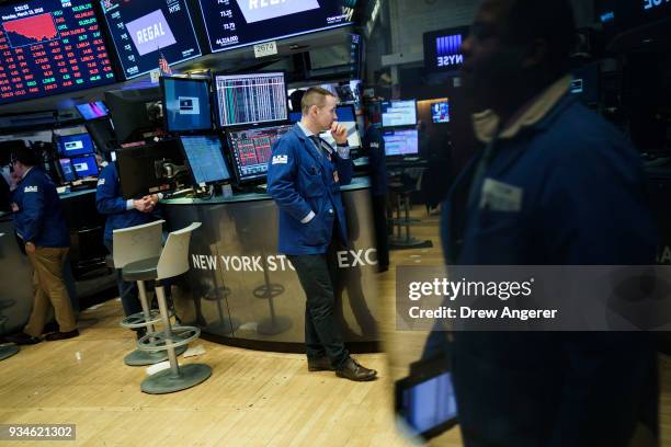 Traders and financial professionals work ahead of the closing bell on the floor of the New York Stock Exchange , March 19, 2018 in New York City. The...