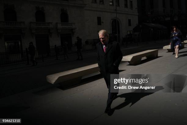 People walk past the New York Stock Exchange , March 19, 2018 in New York City. The Dow Jones industrial average dropped over 330 points on Monday....