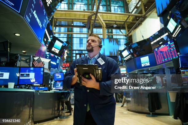 Traders and financial professionals work ahead of the closing bell on the floor of the New York Stock Exchange , March 19, 2018 in New York City. The...