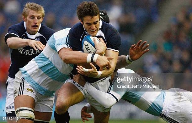 Tom Evans of Scotland is tackled by Patricio Albacete and Horacio Agulla of Argentina during the Bank Of Scotland Corporate Autumn Test match between...