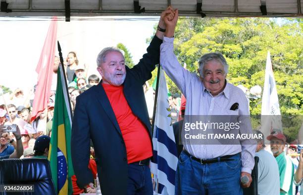 Brazilian former president Luiz Inacio Lula da Silva and Uruguay's former president Jose Mujica acknowledge supporters during a meeting in Santana do...