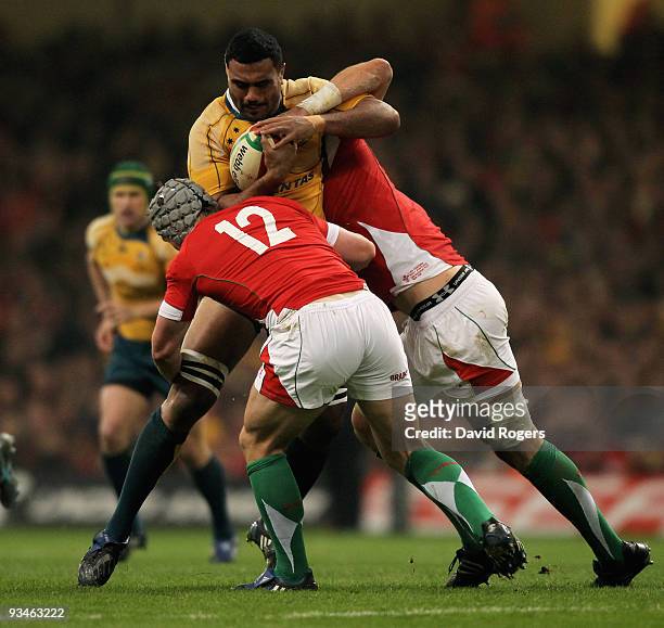 Wycliff Palu of Australia is stopped by Jonathan Davies and Luke Charteris of Wales during the Invesco Perpetual Series match between Wales and...