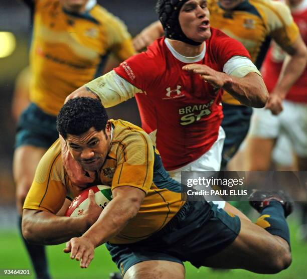 Australia's Tafafu Polota Nau scores a try despite the tackle of Wales' Tom James during the Invesco Perpetual international Rugby Union match...