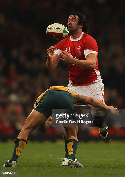 Jonathan Thomas of Wales loses the ball as he is tackled by Quade Cooper of Australia during the Invesco Perpetual Series match between Wales and...