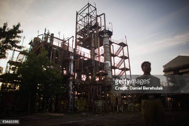 Police man looks on as he tours the site of the deserted Union Carbide factory on November 28, 2009 in Bhopal, India. Twenty-five years after an...