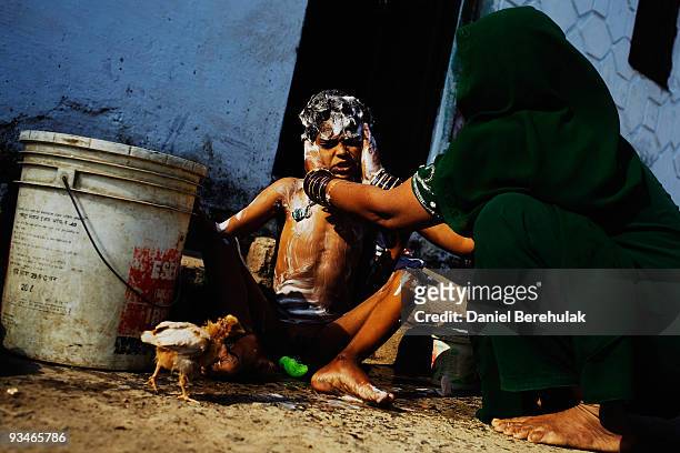 Ten year old Nawab Mian, suffering from mental illness related to the 1984 disaster, receives his morning wash near the site of the deserted Union...