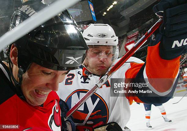 Mark Streit of the New York Islanders and Brian Rolston of the New Jersey Devils battle hard during their game at the Prudential Center on November...