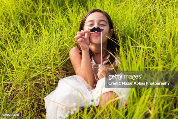 girl with mustache prop having fun outdoor. - nazar abbas stock pictures, royalty-free photos & images