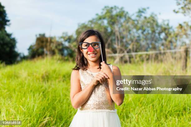 girl playing with eyeglasses props outdoor. - nazar abbas stock pictures, royalty-free photos & images