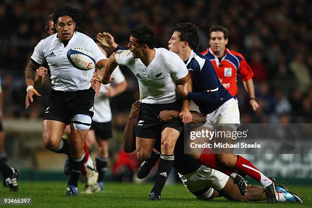 Dan Carter of New Zealand passes to Ma'a Nonu as Francois Trinh- Duc of France closes in during the France v New Zealand International match at the...