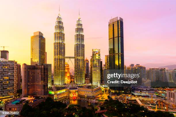 the kuala lumpur city skyline with the petronas towers illuminated at sunset, malaysia. - kuala lumpur stock pictures, royalty-free photos & images