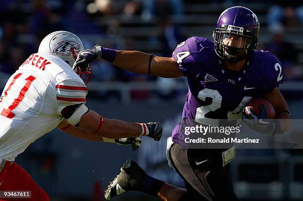 Tailback Joseph Turner of the TCU Horned Frogs runs the ball past Clint McPeek of the New Mexico Lobos at Amon G. Carter Stadium on November 28, 2009...