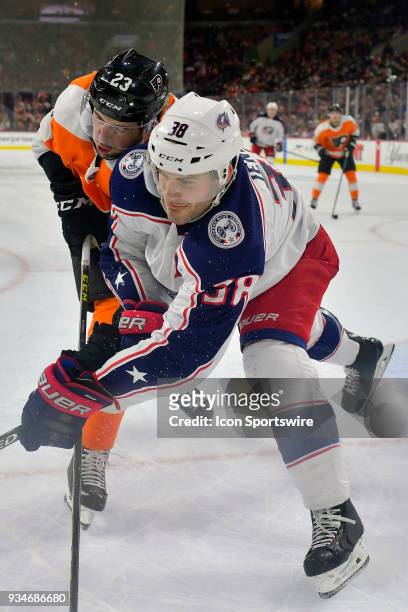 Columbus Blue Jackets center Boone Jenner and Philadelphia Flyers defenseman Brandon Manning wrangle their way towards the puck during the NHL game...