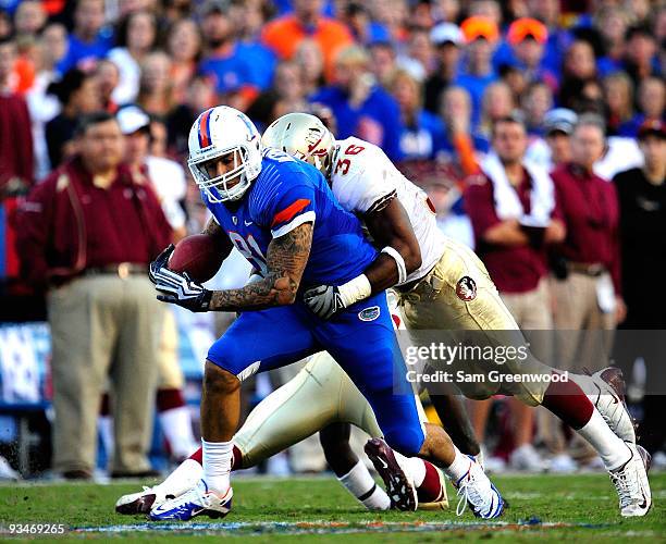 Aaron Hernandez of the Florida Gators runs after making a reception against Dekoda Wason of the Florida State Seminoles at Ben Hill Griffin Stadium...