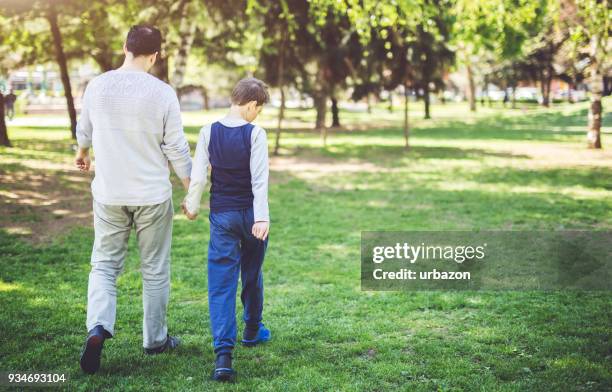 father and son in park - autism awareness stock pictures, royalty-free photos & images