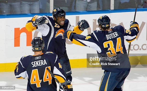 Andrej Sekera, Mike Grier, and Chris Butler of the Buffalo Sabres celebrate Grier's goal in the third period against the Carolina Hurricanes at HSBC...