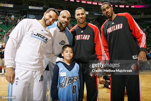 Deron Williams and Carlos Boozer of the Utah Jazz pose for a picture with Brandon Roy and of the Lamarcus Aldridge Portland Trail Blazers and a fan...