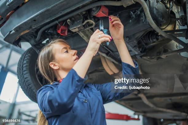 making some adjustments to her car - hydraulic platform stock pictures, royalty-free photos & images