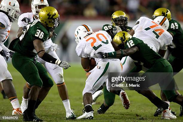 Defensive back Jon Lejiste of the South Florida Bulls tackles running back Damien Berry of the Miami Hurricanes during the game at Raymond James...