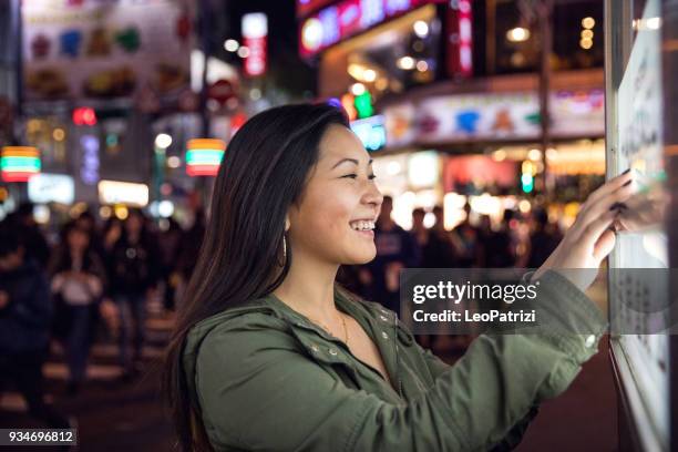 mulher usando uma tela de toque encontrar informações on-line em ruas da cidade de londres - monitor tátil - fotografias e filmes do acervo
