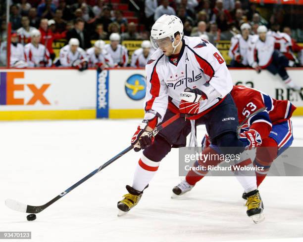 Alex Ovechkin of the Washington Capitals skates with the puck while being defended by Ryan White of the Montreal Canadiens during the NHL game on...