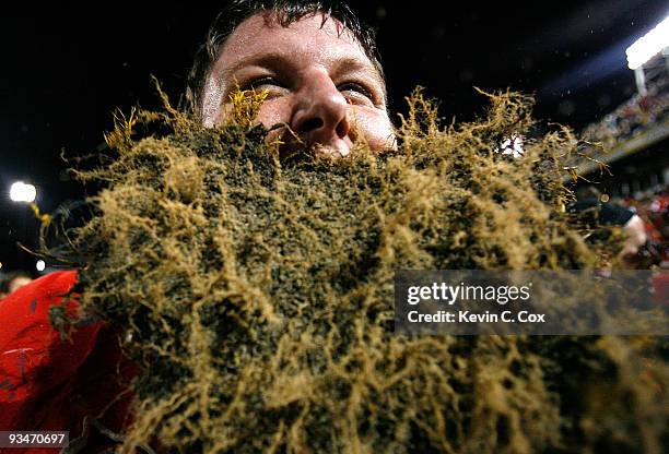 Ben Jones of the Georgia Bulldogs celebrates their 30-24 win over the Georgia Tech Yellow Jackets with a some grass from the end zone at Bobby Dodd...