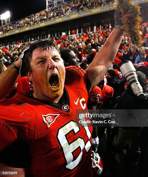 Ben Jones of the Georgia Bulldogs celebrates their 30-24 win over the Georgia Tech Yellow Jackets with a some grass from the end zone at Bobby Dodd...
