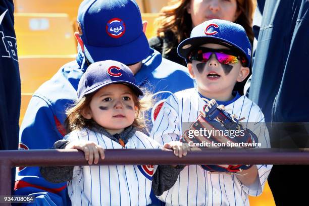 Two young Cubs fans watch the team warm up prior to a game between the Chicago Cubs and Cleveland Indians as part of Big League Weekend on March 18,...