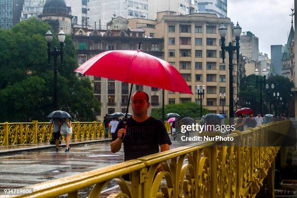 Pedestrians face rain on viaduct in central Sao Paulo, Brazil, on 19 March 2018.