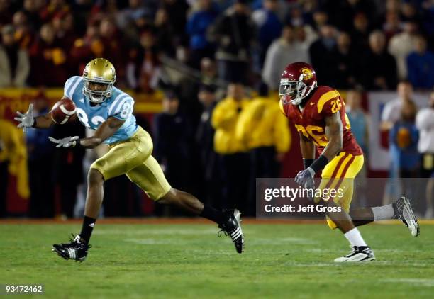 Nelson Rosario of the UCLA Bruins lunges but can't make a catch while being pursued by Will Harris of the USC Trojans in the first half at the Los...
