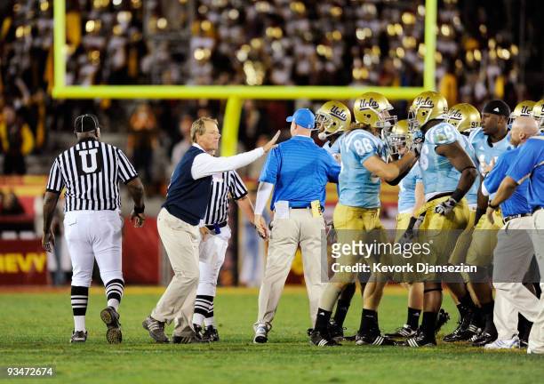 Rick Neuheisel head coach of the UCLA Bruins restrains his players after they nearly had an all-out fight with USC Trojans at the end of the NCAA...