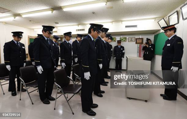 Some 20 Kasumigaseki subway station staff members mark a minute of silence to mourn the victims of the 1995 sarin gas attack by Aum Supreme Truth...