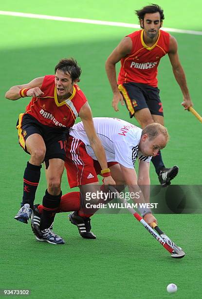 England's Glenn Kirkham is tackled by Spain's Rodrigo Garza and Eduard Arbos during their Champions Trophy field hockey match in Melbourne on...