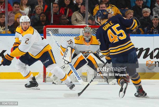 Anthony Bitetto and Pekka Rinne of the Nashville Predators defend against Brendan Guhle of the Buffalo Sabres during an NHL game on March 19, 2018 at...