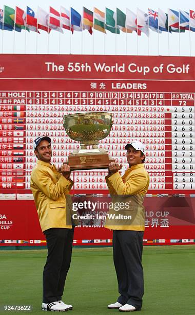 Francesco Molinari and Edoardo Molinari of Italy celebrate with the trophy after winning the Omega Mission Hills World Cup on the Olazabal course on...