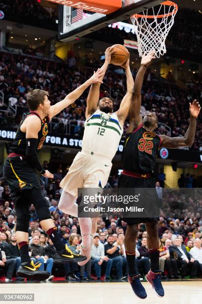Kyle Korver and Jeff Green of the Cleveland Cavaliers try to block Jabari Parker of the Milwaukee Bucks during the first half at Quicken Loans Arena...