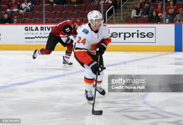 Travis Hamonic of the Calgary Flames advances the puck up ice ahead of Derek Stepan of the Arizona Coyotes during the first period at Gila River...