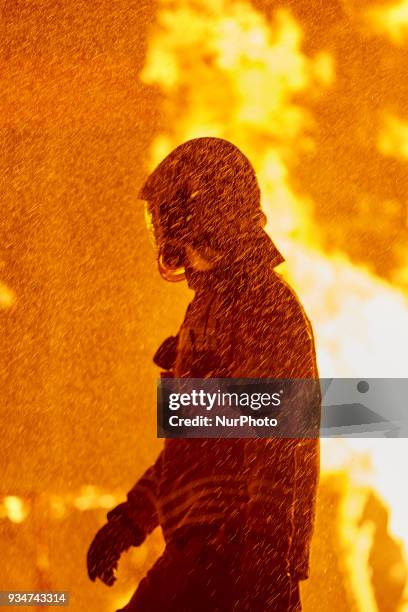 Fireman walks past a burning Falla during the last day of the Las Fallas Festival on March 19, 2018 in Valencia, Spain. The Fallas is Valencias most...