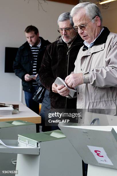 Swiss citizens cast their ballots at the town hall in Uster, near Zurich on November 29, 2009. Switzerland votes on November 29, 2009 on a...