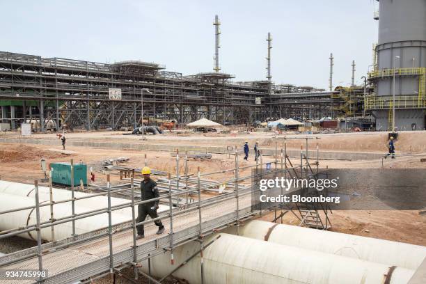 Worker walks over a pedestrian bridge at the the under construction Petronas Nasional Berhad Refinery and Petrochemical Integrated Development...