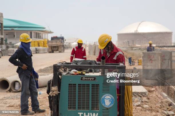 Workers use a Denyo Co. Generator at the under construction Petronas Nasional Berhad Refinery and Petrochemical Integrated Development Project, part...