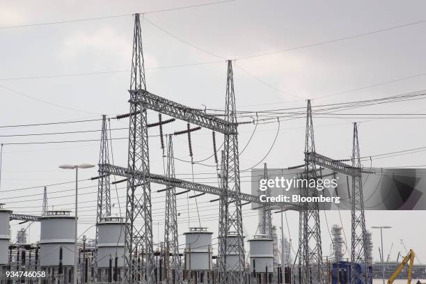 Transmission lines stand at the under construction Petronas Nasional Berhad Refinery and Petrochemical Integrated Development Project, part of the...