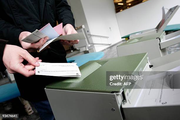 Swiss citizens cast their ballots at the town hall in Uster, near Zurich on November 29, 2009. Switzerland votes on November 29, 2009 on a...